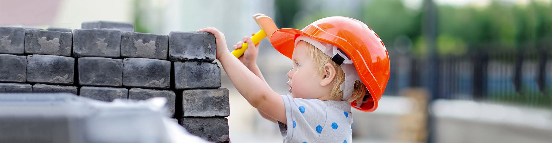 Ein Kind mit Helm auf einer Baustelle als Symbol für guten Schutz.