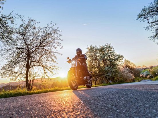 Ein zu versicherndes Motorrad fährt auf einer Landstraße.