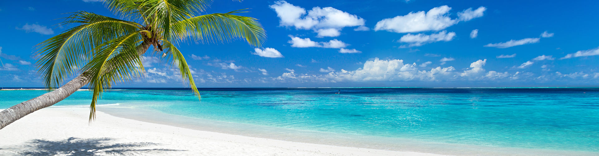 Mit der Auslandsreiseversicherung diesen weißen Sandstrand entspannt genießen.