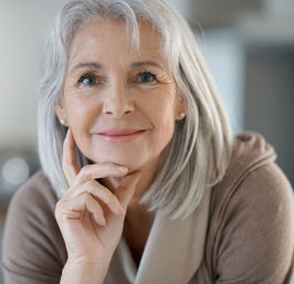 Eine Frau mit mittellangen grauen Haaren schaut in die Kamera