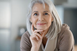 Eine Frau mit mittellangen grauen Haaren schaut in die Kamera