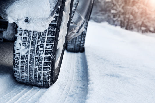 Die Reifen eines Autos in einer Schneespur