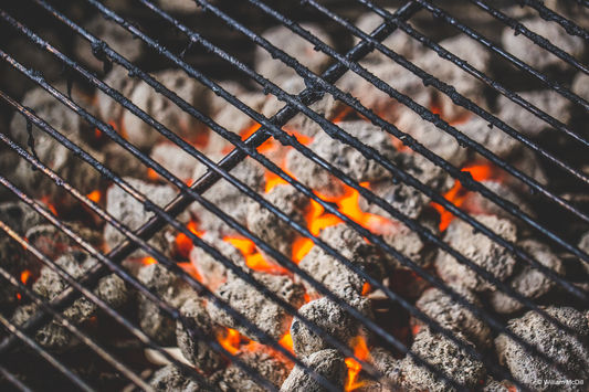 Grillkohle brennt unter dem Grillrost.